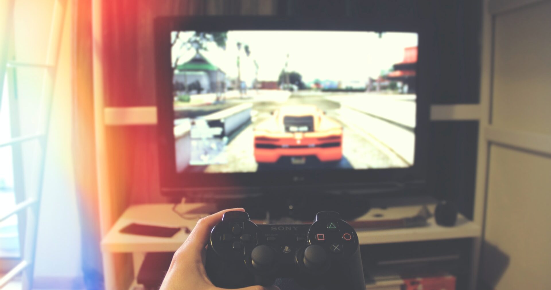 a guy playing GTA 5 on pc screen with a controller in front